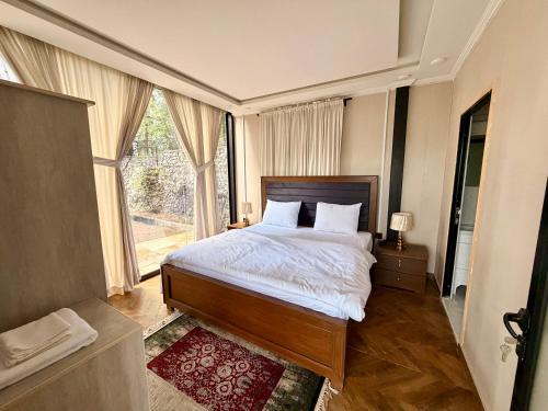 a bedroom with a bed and a large window at The Pinecrest in Nathia Gali