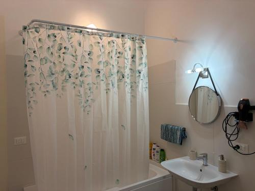 a bathroom with a shower curtain and a sink at Elisir house in Palermo