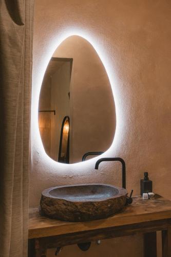 a bathroom with a stone sink with a mirror at Ánimo Perro in Sayulita