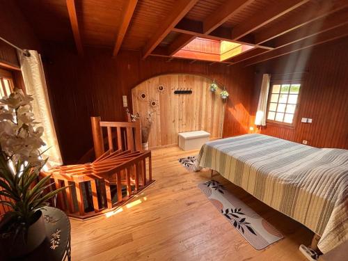 a bedroom with a bed and a wooden floor at Gîtes du Fanal in Ébéon