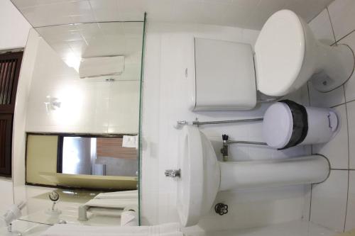 a bathroom with a mirror and a sink and a toilet at Amuarama Hotel in Fortaleza