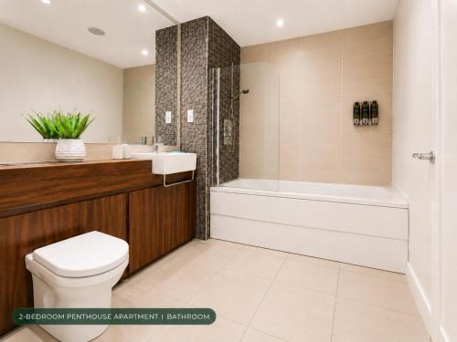 a bathroom with a toilet and a tub and a sink at CK Serviced Apartments, Titanic Quarter, Belfast in Belfast