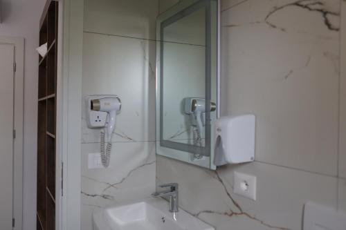 a bathroom with a sink and a mirror at Bebis Rooms in Orikum