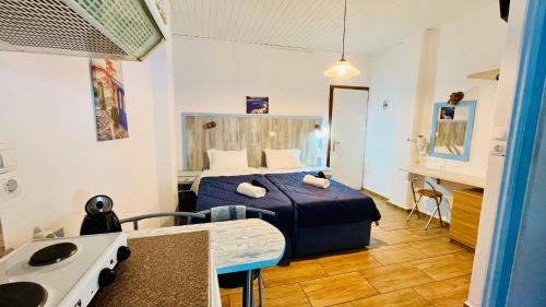 a small room with a bed and a kitchen at Anthis Studios in Pythagoreio
