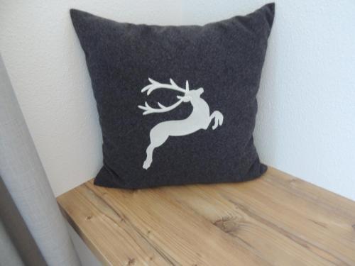 a black pillow with a white deer on it at Apart Gaberhof in Tarrenz