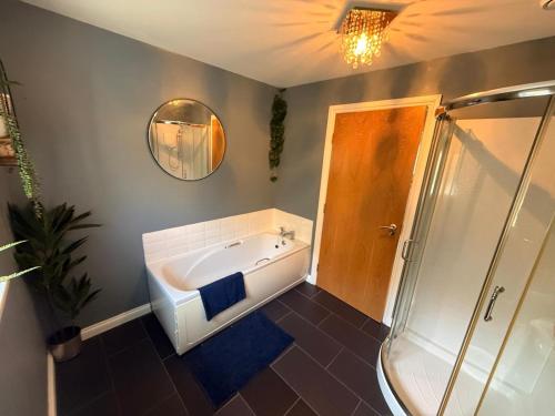 a bathroom with a bath tub and a shower at 6 Pegasus Place in Lerwick