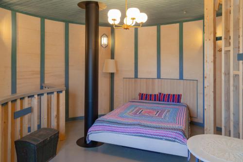 a bedroom with a bed and a table and a lamp at Biskopsdal in Karuna