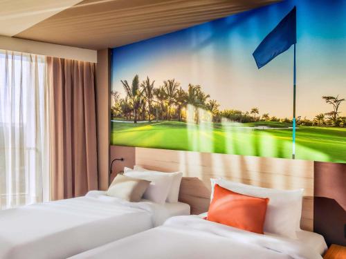 two beds in a hotel room with a painting on the wall at Novotel Itu Terras de São José Golf & Resort in Itu