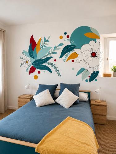 a bedroom with a bed with a flower mural on the wall at Appartement bleu in Eymoutiers