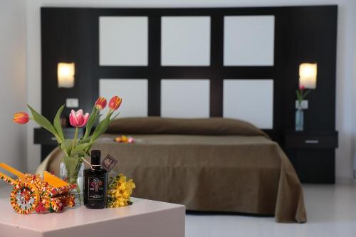 a bedroom with a bed and flowers on a table at Hotel Admeto in Marinella di Selinunte