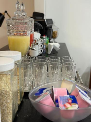 a table topped with glasses and a bowl of food at Hotel Santorine Plaza - Itabira - Próximo a Fundação Cultural Carlos Drummond Andrade in Itabira