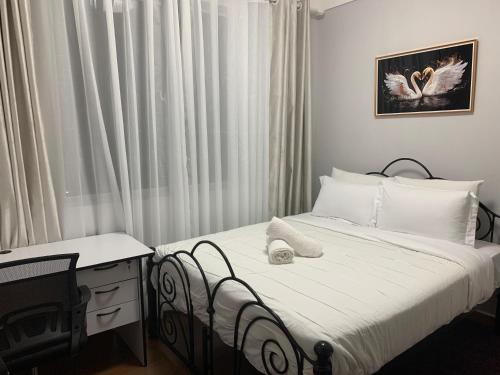 a bedroom with a bed and a desk and a window at EM Homes Modern 1-Bedroom Apartment with Pool 15 Minutes from JKIA Airport in Marimbeti