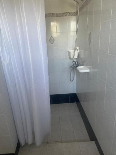 a bathroom with a shower curtain and a sink at Melina's sunset-Cozy studio with amazing sea view and sunset in Myrties