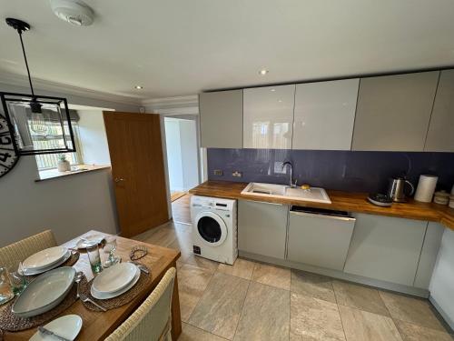 a kitchen with a sink and a washing machine at Shepherds Barn in Beamish