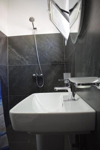 a bathroom with a white sink and a mirror at Old Bridge Guest House in Gjirokastër