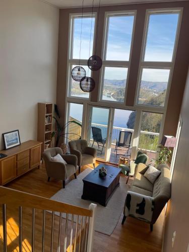 a living room filled with furniture and large windows at Apartment with great sunset view! in Lyngdal