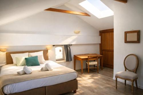 a bedroom with a bed with a table and a chair at Hôtel restaurant Clos des Sullys in Montclus
