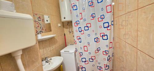 a bathroom with a shower curtain with a toilet and a sink at Studio Rose in Gajac