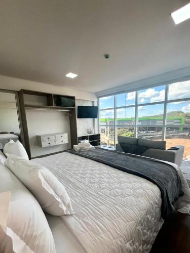 a bedroom with a large bed with a large window at Hotel Pasqualotto in Chopinzinho
