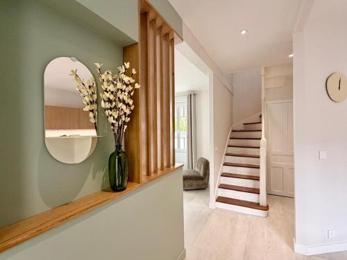 a hallway with a vase with flowers in it at GIte de la Grande Plage in Pléneuf-Val-André