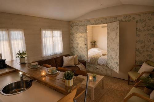 a living room with a sink and a bedroom at Tiny house met Coldtub 4pers The Firefly in Amblève
