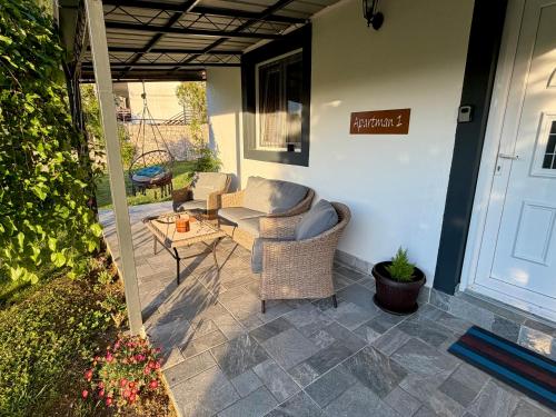 a patio with two chairs and a table on a porch at Sunlight Cottage Maya in Virpazar
