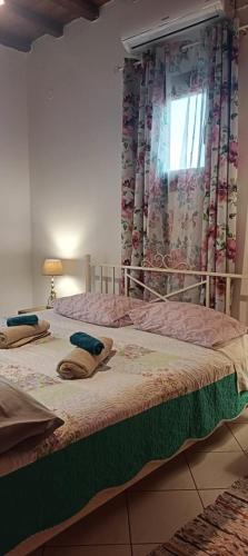 a bedroom with two beds and a window with curtains at Villa Rahes Kofini in Mykonos