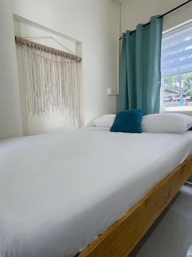 a large bed in a bedroom with a window at Downtown Hostel Jamaica in Kingston