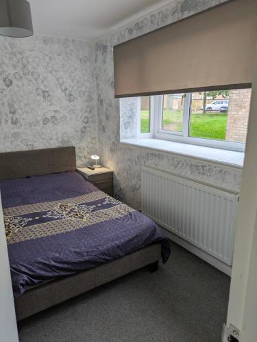 a bedroom with a bed and a window at Corby Double & En-suite Rooms NN17 2LZ area Ideal Contractors Short & Long stays Opposite Lodge Park Leisure Center in Corby