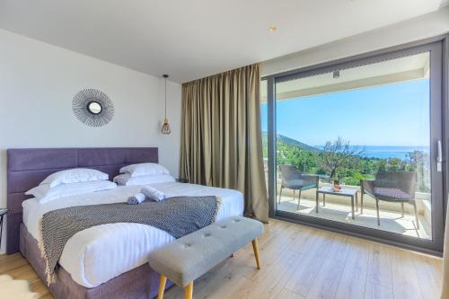 a bedroom with a large bed and a sliding glass door at Villa Bellevue Bast in Baška Voda