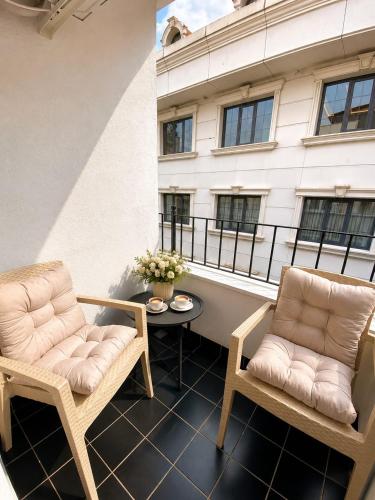 two chairs and a table on a balcony with a building at Huzur Apart Hotel in Istanbul