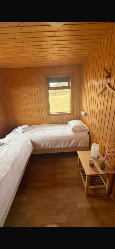 a small room with two beds and a table at Summerhouse Torfalundur in Blönduós