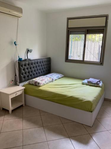 a bedroom with a large bed with a window at באר מרים in Ashkelon