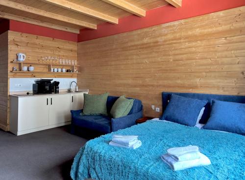 a bedroom with a blue bed and a kitchen at New Gudauri Studio N207 in Suites! in Gudauri