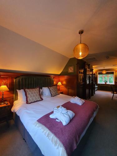 a bedroom with a large bed with towels on it at Bel And The Dragon-Churt in Farnham