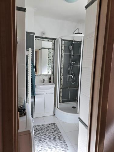 a white bathroom with a shower and a sink at Post 25 in Slezská Ostrava