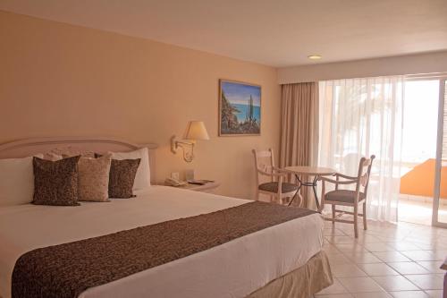 a hotel room with a bed and a table with chairs at Posada Real Los Cabos in San José del Cabo