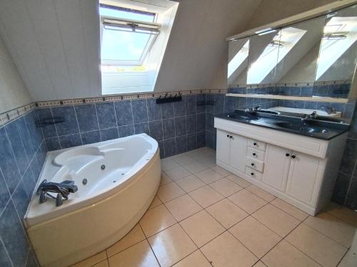a large bathroom with a tub and a sink at La maison du petit peintre in Villaines-sous-Lucé
