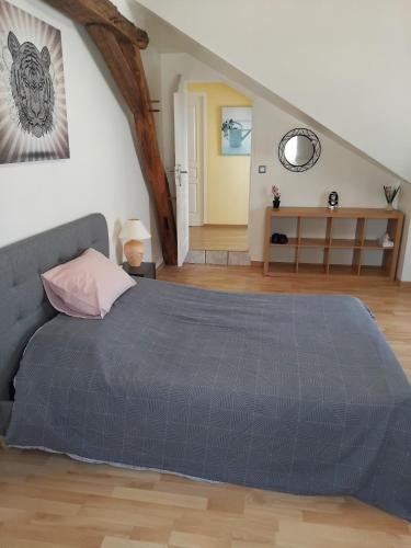 a bedroom with a large bed and a staircase at La maison du petit peintre in Villaines-sous-Lucé