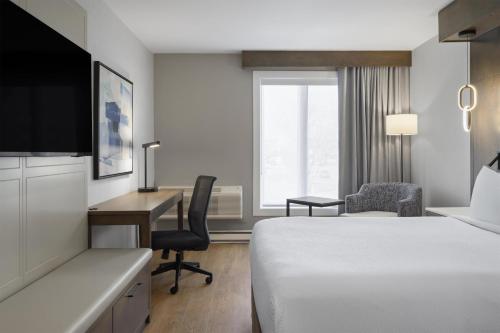 a hotel room with a bed and a desk with a computer at Best Western Premier Hotel Aristocrate in Quebec City