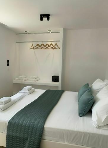 a bedroom with a large bed with green and white pillows at Elounda Port Apartment in Elounda