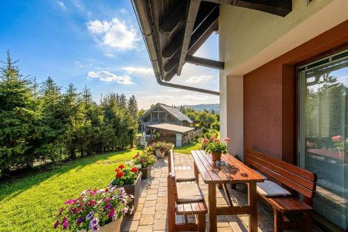 a patio with a wooden table and chairs on a house at Sunny Weekend Sauna House - Happy Rentals in Preserje