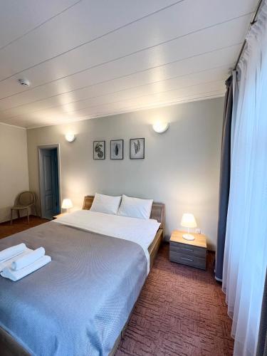 a bedroom with a large bed and two lamps at ThaiThanee COZY HOUSE in Palanga