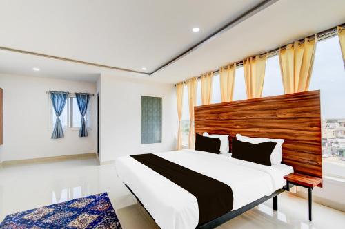 a bedroom with a large bed and a large window at Hotel O Inn In Town in Sangāreddi