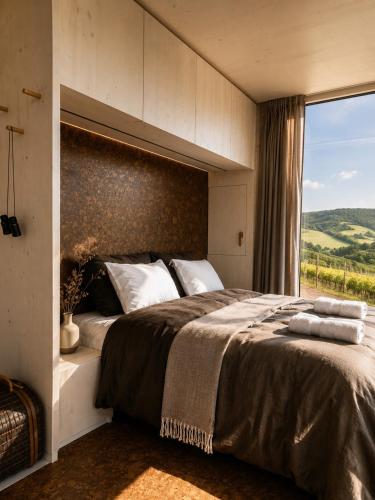 a bedroom with a large bed with a large window at Glamping Domik Tokaj in Malá Tŕňa