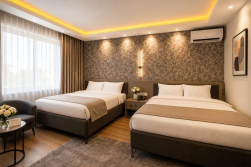 a hotel room with two beds and a chair at Huzur Apart Hotel in Istanbul