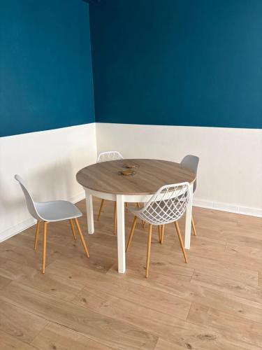 a wooden table and two chairs in a room at Bolbec Église in Bolbec