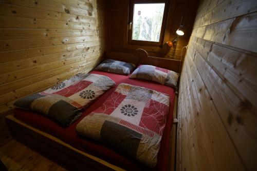 a bedroom with a bed in a wooden cabin at Camp Sibley Hütte in Oberdambach