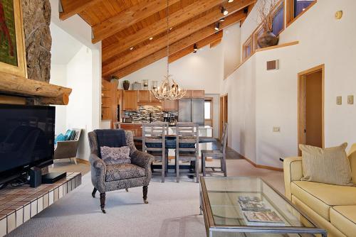 a living room with a couch a chair and a tv at 229 #36 by SkyRun Aspen in Snowmass Village