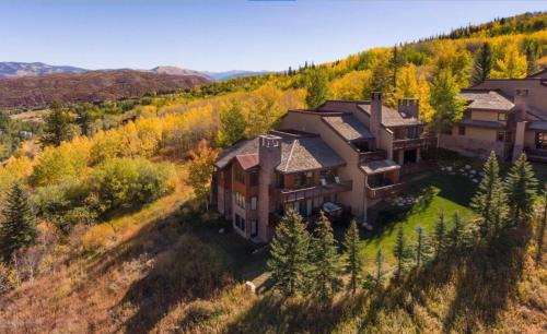 an aerial view of a large house on a hill at 229 #36 by SkyRun Aspen in Snowmass Village